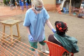 A nurse of the 'Doctors without Borders' ('Medecin sans frontieres') medical aid organisation examines a patient in the in-take area at a center for victims of the Ebola virus in Guekedou, on April 1, 2014. The viral haemorrhagic fever epidemic raging in Guinea is caused by several viruses which have similar symptoms -- the deadliest and most feared of which is Ebola. AFP PHOTO / SEYLLOU