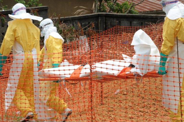 Staff of the 'Doctors without Borders' ('Medecin sans frontieres') medical aid organisation carry the body of a person killed by viral haemorrhagic fever, at a center for victims of the Ebola virus in Guekedou, on April 1, 2014. The viral haemorrhagic fever epidemic raging in Guinea is caused by several viruses which have similar symptoms -- the deadliest and most feared of which is Ebola. AFP PHOTO / SEYLLOU