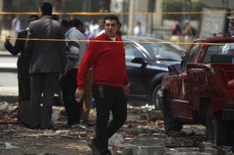 Police officers inspect near the site of a series of explosions in front of Cairo University April 2, 2014. The series of explosions outside Cairo University killed two people on Wednesday, including a police brigadier-general, security officials said, in what appeared to be the latest militant attack in a fast-growing insurgency. REUTERS/Amr Abdallah Dalsh (EGYPT - Tags: POLITICS CIVIL UNREST)
