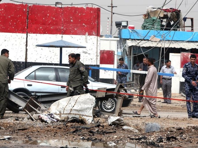 Iraqi police secure the site of a car bomb explosion at a checkpoint in the Suweirah area, 45 kms south of Baghdad, on April 21, 2014. A suicide bomber detonated a vehicle rigged with explosives at the police checkpoint, killing 10 people, an officer and a medical source said. Violence has killed at least 490 people in Iraq this month and upwards of 2,700 this year, according to AFP figures based on security and medical sources. AFP PHOTO/AHMAD AL-RUBAYE