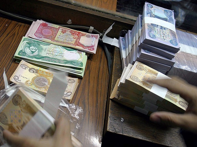 The newly-designed bills of the Iraqi currency are seen in the al-Khadhra'a bank in Baghdad, Wednesday 15 October 2003. The official exchange of the old Iraqi currency for the new bills began on Wednesday in Iraq. The banknotes, bearing the image of Saddam Hussein, are to be exchanged over the next three months for the new currency, depicting historical and cultura