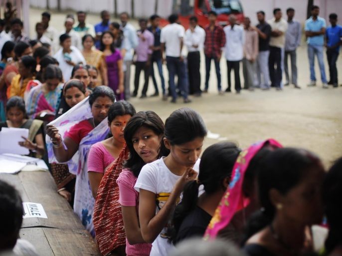 Indian voters wait in queues to cast their votes during the first phase of elections in Dibrugarh, in the northeastern state of Assam, India, Monday, April 7, 2014. Indians began voting Monday in the world's biggest election, with the opposition heading into the polls with strong momentum on promises of economic renewal. The country's 814 million eligible voters will vote in stages over the next five weeks. (AP Photo/Altaf Qadri)