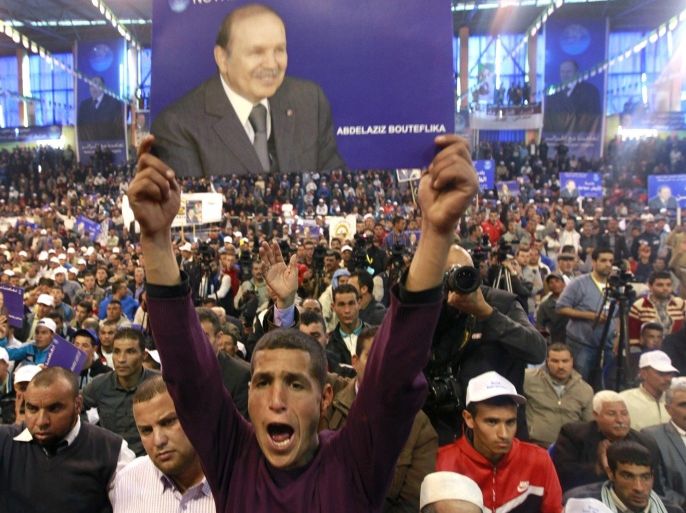 A supporter of current Algerian President and candidate in the forthcoming presidential election, Abdelaziz Bouteflika, holds a placard of him during a rally meeting in Chelf April 1, 2014. Campaigning began on March 23 for an Algerian presidential election widely seen as a one-horse race that will ensure President Abdelaziz Bouteflika's a fourth term. REUTERS/Louafi Larbi (ALGERIA - Tags: POLITICS ELECTIONS)