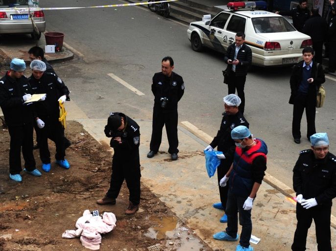 Investigators work at the scene where attackers armed with knives killed three people in Changsha, central China's Hunan province on March 14, 2014. Attackers armed with knives killed three people in China on March 14, an official said, ruling out terrorism two weeks after a mass stabbing blamed on Xinjiang militants left 29 people dead and stunned the nation. CHINA OUT AFP PHOTO