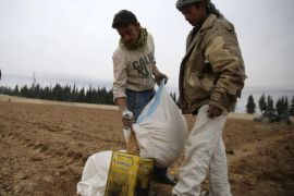 Farmers carry wheat bags before planting in eastern al-Ghouta, near Damascus December 26, 2013. Picture taken December 26, 2013. REUTERS/Mohammed Abdullah (SYRIA - Tags: POLITICS CIVIL UNREST CONFLICT)