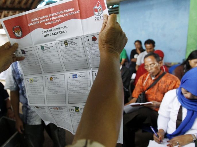An election volunteer shows a ballot to witnesses while counting ballots for the parliamentary elections in Jakarta, Indonesia, Wednesday, April 9, 2014. Polls opened Wednesday for nearly 187 million Indonesians eligible to vote in single-day legislative elections, a huge feat in the still-young democracy that's expected to help clear the path for the country's next president. (AP Photo/Achmad Ibrahim)