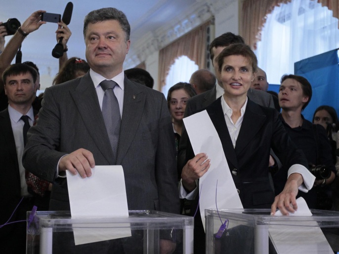 بوروشينكو وزوجته يدليان بصوتيهما في كييف (أسوشيتد برس)