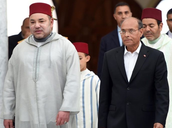 Moroccan king Mohamed VI (C-L) is greeted by Tunisian President Moncef Marzouki (C-R) upon his arrival on May 30, 2014 in Tunis. King Mohamed arrived in Tunis for his first official visit to the country since the January 2011 popular uprising that toppled a decades-old dictatorship, an AFP photographer said. AFP PHOTO / FETHI BELAID