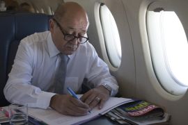 French Defence Minister Jean-Yves Le Drian looks at documents in a plane as he flies over Poland on April 29, 2014. Le Drian is on a one-day visit to Poland. Le Drian is on a one-day visit to Poland. AFP PHOTO / JOEL SAGET