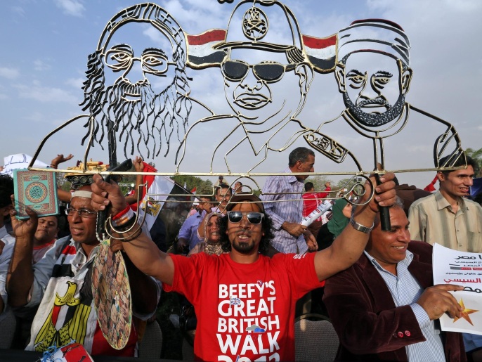 مؤيدون للسيسي يحملون رسما له ولشيخ الأزهر والبابا تواضروس أثناء مظاهرة تأييد له بالقاهرة أمس السبت (الأوروبية)