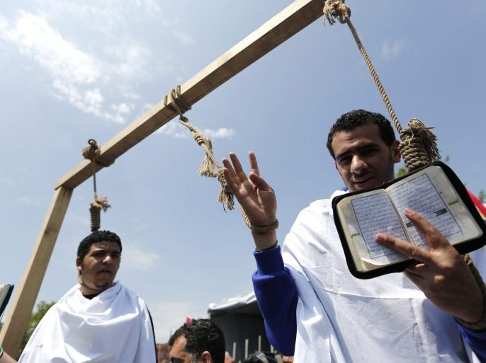 Egyptians living in Turkey pose with Koran and symbolic hanging ropes during a protest against death sentences in Egypt as they start hunger strike for two days in front of Yeni (New) Mosque at Ottoman era in Istanbul, Turkey, 13 May 2014. The Solidarity Platform with Egyptian People and some Turkish NGO's representatives gather for a press conference to protest against recent death sentences in Egypt.