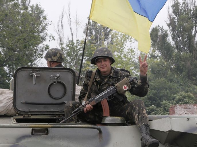 A Ukrainian soldier shows a V-sign as he moves to Slovyansk, Ukraine, Saturday, May 31, 2014. The Ukrainian government army forces have established a ring of checkpoints around Slovyansk, the epicenter of the Ukrainian conflict. (AP Photo/Efrem Lukatsky)