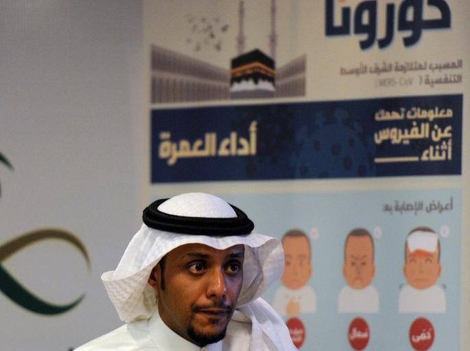 A Saudi man walks in front of a coronavirus poster prior to a press conference held by newly appointed Saudi acting Minister of Health Adel bin Mohamed Faqih on the Middle East Respiratory Syndrome (MERS) on April 29, 2014 in Riyadh. The health ministry reported more MERS cases in the city of Jeddah, prompting authorities to close the emergency department at the city's King Fahd Hospital. AFP PHOTO/FAYEZ NURELDINE