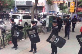 In this photo released by China's Xinhua News Agency, police officers stand guard near a blast site which has been cordoned off, in downtown Urumqi, capital of northwest China's Xinjiang Uygur Autonomous Region, Thursday, May 22, 2014. Attackers crashed a pair of vehicles and tossed explosives in an attack Thursday near an open air market in the capital of China's volatile northwestern region of Xinjiang, leaving an unknown number of people dead and injured, state media reported. (AP Photo/Cao Zhiheng)