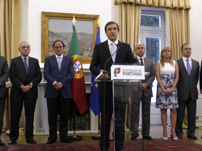 Portugal's Prime Minister Pedro Passos Coelho, centre, addresses a statement to the nation with the Ministers of his government at the Sao Bento palace, the premier's official residence, in Lisbon, Sunday, May 4, 2014. Passos Coelho announced there will be a clean exit for the country after finishing its budget adjustment program on May 17 linked to a euro 78 billion (US$108.1 billion) bailout needed in 2011. (AP Photo/Francisco Seco)