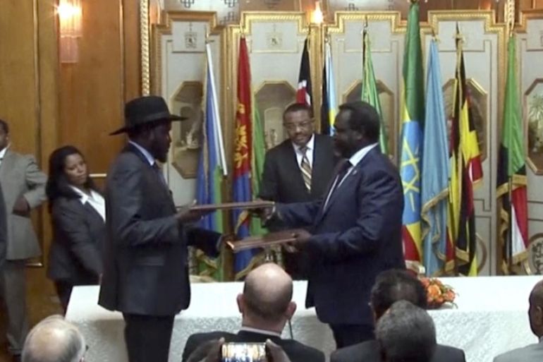 In this Friday, May 9, 2014 image made from video, South Sudan's President Salva Kiir, center left, and rebel leader Riek Machar, center right, exchange the signed documents in Addis Ababa, Ethiopia. The South Sudan's president has reached a cease-fire agreement with the rebel leader, an African regional bloc said Friday, after a vicious cycle of revenge killings drew international alarm. (AP Photo/AP Video)