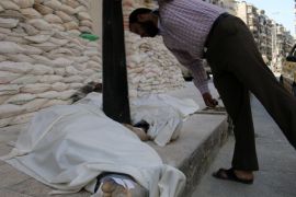 A Syrian inspects bodies wrapped in shrouds following a reported air strike by government forces on May 30, 2014 in the northern Syrian city of Aleppo. Barrel bombings and other Syrian government air raids on rebel districts of Aleppo and surrounding areas have killed 1,963 civilians since January, including 567 children, a monitoring group said on May 30, 2014. AFP PHOTO / AMC / KHALED KHATIB