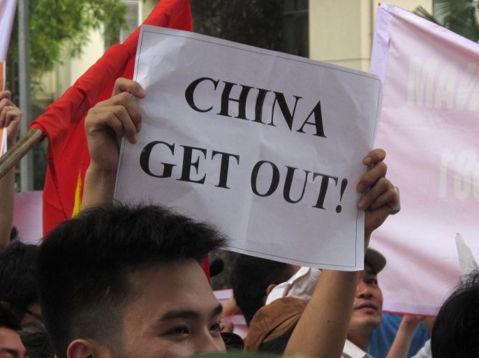 A Vietnamese protester holds a banner in a rally against Beijing's deployment of an oil rig in the contested waters of the South China Sea, outside the Chinese Embassy on Sunday, May 11, 2014 in Hanoi, Vietnam. The deployment of the rig has a triggered a tense standoff in the ocean and raised fears of confrontation between the neighboring countries. (AP Photo/Chris Brummitt)