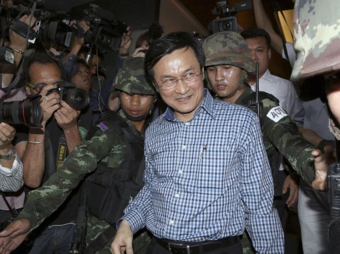 Former Thai Education Minister Chaturon Chaisang, center, walks after being detained by soldiers after a news conference at the Foreign Correspondents' Club of Thailand in Bangkok, Thailand Tuesday, May 27, 2014. Thai troops detained the Cabinet minister who defiantly emerged from hiding on Tuesday to condemn last week's military coup and urge a return to civilian rule, in the first public appearance by any member of the ousted government. (AP Photo/Apichart Weerawong)