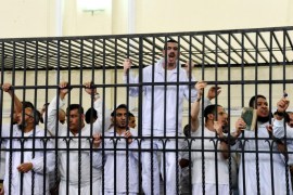 Supporters of the Muslim Brotherhood and other Islamists gesture from the defendants cage as they receive sentences ranging from death by hanging for one, life in prison for 13 and 8-15 years for the others after they were convicted of murder, rioting, and violence in a mass trial in Alexandria, Egypt, Monday, May 19, 2014. Mahmoud Hassan Ramadan Abdel-Nabi was sentenced to death for the killing a nine-year-old child by throwing him off the roof of a building during violent protests following the ouster of former Islamist President Mohammed Morsi last July. The roof incident was one of the most dramatic acts of violence on a day in which 16 other people were killed in Alexandria. (AP Photo/Heba Khamis)