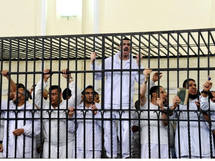 Supporters of the Muslim Brotherhood and other Islamists gesture from the defendants cage as they receive sentences ranging from death by hanging for one, life in prison for 13 and 8-15 years for the others after they were convicted of murder, rioting, and violence in a mass trial in Alexandria, Egypt, Monday, May 19, 2014. Mahmoud Hassan Ramadan Abdel-Nabi was sentenced to death for the killing a nine-year-old child by throwing him off the roof of a building during violent protests following the ouster of former Islamist President Mohammed Morsi last July. The roof incident was one of the most dramatic acts of violence on a day in which 16 other people were killed in Alexandria. (AP Photo/Heba Khamis)