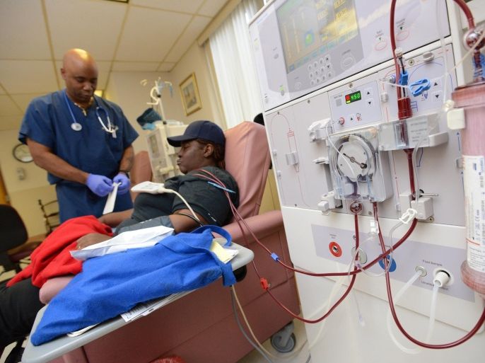 In this Dec. 16, 2013 photo, charge nurse Steve Belcher, left, works with patient Antoinette Swearinger at the DaVita Downtown Dialysis Center in Baltimore. The center is one of many in Maryland that will be affected by medicare reimbursement cuts to dialysis centers. (AP Photo/The Daily Record, Maximilian Franz)
