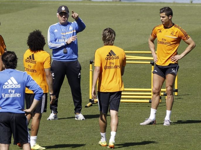 Real Madrid's Italian coach Carlo Ancelotti (C), gives instructions to his players, Portuguese forward Cristiano Ronaldo (R), countryman Fabio Coentrao (2R), Brazilian defender Marcelo Vieira (2R), and Croatian Luka Modric (L), among others, during a team's training session at Valdebebas Sports Complex in Madrid, Spain, 16 May 2014, on the eve of the Spanish Primera Division soccer match that the team will play against Espanyol.