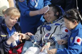 Russian, Japanese and NASA specialists help Japanese astronaut Koichi Wakata shortly after the Russian Soyuz TMA-11M space capsule landed, some 150 kilometers (93 miles) southeast of town Dzhezkazgan, Kazakhstan, Wednesday, May 14, 2014. The Soyuz space capsule with Wakata, Russian cosmonaut Mikhail Tyurin and U.S. astronaut Rick Mastracchio, returning from a half-year mission to the International Space Station, landed safely Wednesday on the steppes of Kazakhstan. (AP Photo/Dmitry Lovetsky, Pool)