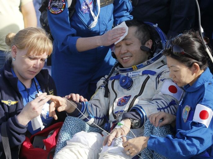 Russian, Japanese and NASA specialists help Japanese astronaut Koichi Wakata shortly after the Russian Soyuz TMA-11M space capsule landed, some 150 kilometers (93 miles) southeast of town Dzhezkazgan, Kazakhstan, Wednesday, May 14, 2014. The Soyuz space capsule with Wakata, Russian cosmonaut Mikhail Tyurin and U.S. astronaut Rick Mastracchio, returning from a half-year mission to the International Space Station, landed safely Wednesday on the steppes of Kazakhstan. (AP Photo/Dmitry Lovetsky, Pool)