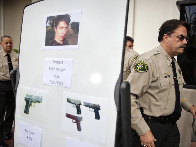Santa Barbara County Sheriff Bill Brown, right, walks past a board showing the photos of suspected gunman Elliot Rodger and the weapons he used in Friday night's mass shooting that took place in Isla Vista, Calif., after a news conference on Saturday, May 24, 2014, in Santa Barbara, Calif. Sheriff's officials say Rodger, 22, went on a rampage near the University of California, Santa Barbara, stabbing three people to death at his apartment before shooting and killing three more in a crime spree through a nearby neighborhood. (AP Photo/Jae C. Hong)