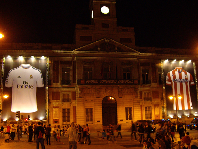 ‪مبنى حكومة مدريد الإقليمية وعلى واجهته قميصين عملاقين للريال وأتليتيكو‬  (الجزيرة)