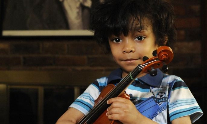 Caesar Sant (4) poses after playing Vivaldi at his home in Winston-Salem, N.C., Monday April 15, 2013. Sant who is highly gifted in music and math, has suffered two strokes as a result of his having Sickle Cell Anemia. While a complete blood transfusion has helped his recovery, his parents believe the only cure for his SCA is a stem cell transplant, and are trying to raise $100,000 for it.