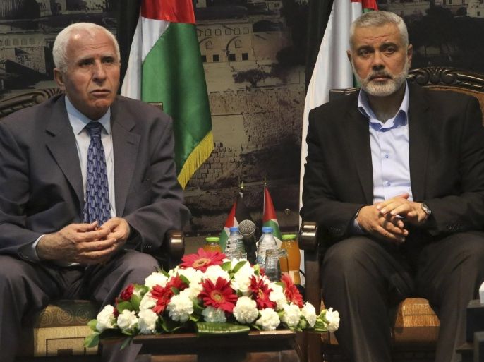 File - In this April 22, 2014 file photo, Gaza's Hamas Prime Minister Ismail Haniyeh, right, and senior Fatah official Azzam al-Ahmad meet in Gaza for talks aimed at reaching a reconciliation agreement between the two rival Palestinian groups, Hamas and Fatah. Propelled by crises, rivals Hamas and Fatah are moving toward forming a unity government by next week, in what appears to be their most promising attempt yet to end a seven-year rift that weakened the Palestinian case for statehood. (AP Photo/Hatem Moussa, File)