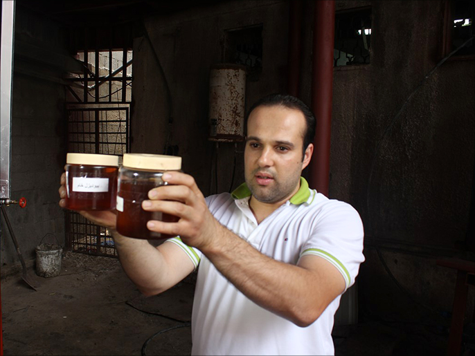المهندس شرف يحمل عينة من الوقود الحيوي المنتج من مخلفات الطعام(الجزيرة نت)