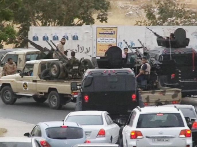 In this image made from video provided by the Libyan national army via AP Television, vehicles with heavy artillery of the Tripoli joint security forces move closer to the parliament building after troops of Gen. Khalifa Hifter targeted Islamist lawmakers and officials at the parliament in Tripoli, Libya, Sunday, May 18, 2014. Forces loyal to a rogue Libyan general attacked the country's parliament Sunday, expanding his eastern offensive against Islamists into the heart of the country's capital. (AP Photo/Libyan national army)