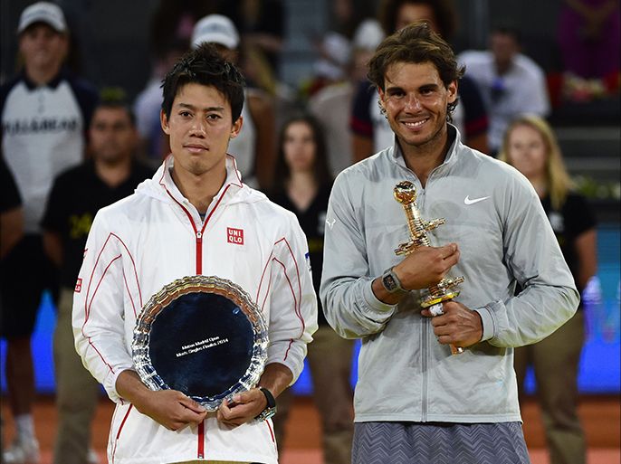 Winner Spanish player Rafael Nadal (R) and Japanese player Kei Nishikori (L) pose with the trophies after the men's singles final tennis match of the Madrid Masters at the Magic Box (Caja Magica) sports complex in Madrid on May 11, 2014. Rafael