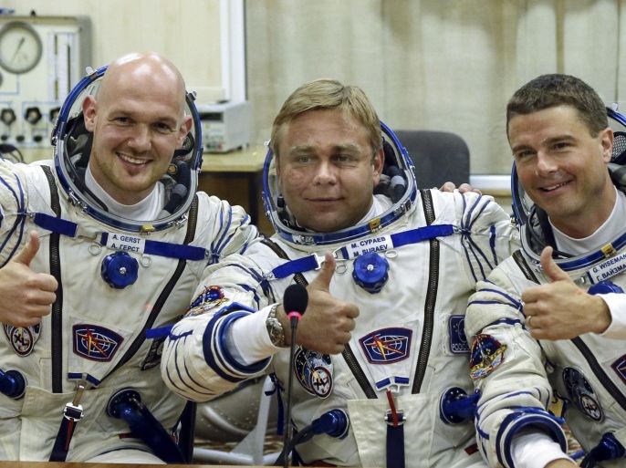 European Space Agency's astronaut Alexander Gerst, left, Russian cosmonaut Maxim Suraev, center, and NASA astronaut Reid Wiseman, crew members of the mission to the International Space Station, ISS, gesture prior the launch of Soyuz-FG rocket at the Russian leased Baikonur cosmodrome, Kazakhstan, Wednesday, May 28, 2014. (AP Photo/Sergei Ilnitsky, Pool)