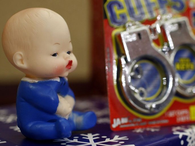 A baby doll and a pair of plastic handcuffs are seen on display at a news conference where the U.S. Public Interest Research Group (PIRG) announced its 25th annual Trouble in Toyland report, in Washington November 23, 2010. The new report reveals the results of the consumer advocacy group's laboratory testing for toxic chemicals, and identifies toys that PIRG says pose choking and other hazards. The doll, manufacturer unknown, is an example of toys that the group says contains phthalates and the plastic handcuffs, manufacturer unknown, is an example of toys that the group says may contain toxic antimony.