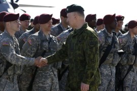 Lithuania's Chief of Defence Lieutenant General Arvydas Pocius welcomes US paratroopers as first American troops arrived at the Lithuanian air force base in Siauliai, Lithuania, Saturday, April 26, 2014. US troops arrived Saturday in Lithuania to participate in NATO maneuvers, at a time of increased tension in nearby Ukraine.(AP Photo/Mindaugas Kulbis)