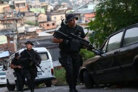 RIO DE JANEIRO, BRAZIL - MAY 13: Officers from the CORE police special forces patrol during an operation to search for fugitives in the Complexo do Alemao pacified community, or 'favela' on May 13, 2014 in Rio de Janeiro, Brazil. Ahead of the 2014 FIFA World Cup, Rio has seen an uptick in violence in its pacified slums. A total of around 1.6 million Rio residents live in shantytowns, many of which are controlled by drug traffickers.