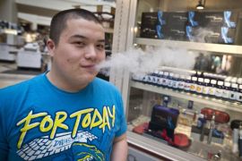 FILE - In this March 18, 2014 file photo, Jesse Ly smoked his e-cigarette at the Smokeless Smoking kiosk at the Roseville Mall in Roseville, Minn. Democrats who control the Minnesota Legislature can brag about key accomplishments in the just-completed session, including a big boost in the minimum wage and a tougher statewide anti-bullying law. But they needed and got help from Republicans to push through $1.1 billion in spending on construction projects, major tax relief and legalized medical marijuana. (AP Photo/The Star Tribune, Renee Jones Schneider)