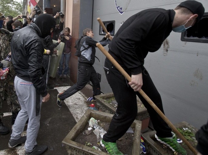 Pro-Russian protesters break the vehicle access gate at a police station building in Odessa, Ukraine, Sunday, May 4, 2014. Several prisoners that were detained during clashes that erupted Friday between pro-Russians and government supporters in the key port on the Black Sea coast were released under the pressure of protesters that broke into a local police station and received a hero's welcome by crowds. (AP Photo/Vadim Ghirda)