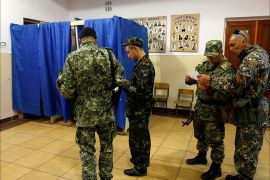 Armed pro-Russia militia men line-up outside a polling booth before voting at a polling station during a referendum in the eastern Ukrainian city of Slaviansk May 11, 2014