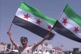 معارض سوري يرفع اعلام الثورة قبالة السفارة التي شهدت الانتخابات الرئاسية اليوم