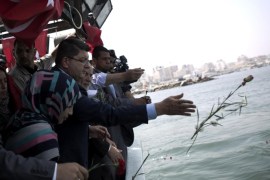 Turkish ambassador in Palestine Mustafa Sarnic (C) throws red roses into the sea in the Gaza City port on May 29, 2014, in memory of the martyrs of the Turkish ship Mavi Marmara that was part of a flotilla trying to break the Gaza blockade, who were killed when Israeli naval commandos seized the ship in May 2010. AFP PHOTO/MOHAMMED ABED