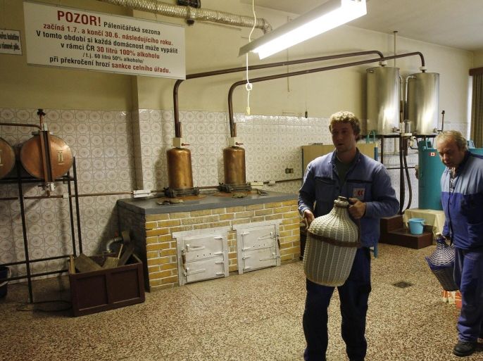 In this photo taken in Breznice, village in eastern Czech Republic, Thursday, Sept. 20, 2012, customers carry out their liquor made at a private distillery. Czech people continue their centuries-old tradition of home distilled spirits that remains the only option to legally obtain hard liquors after sales and exports were banned following a wave of methanol poisoning that has killed at least 23 people.