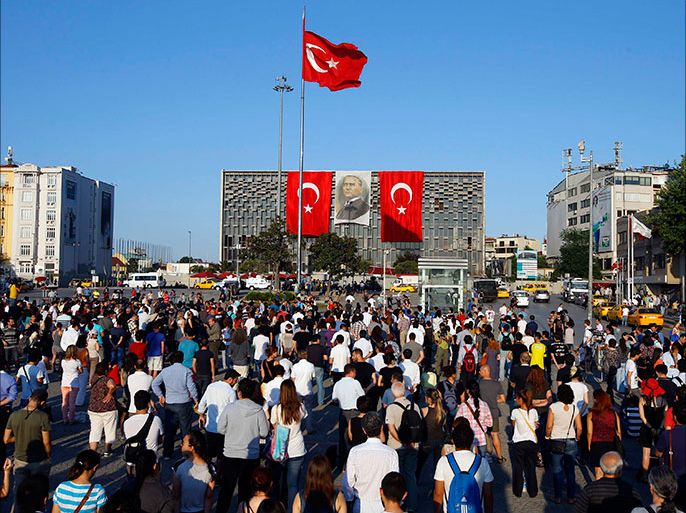 People stand facing Ataturk Cultural Center during a protest at Taksim Square in Istanbul June 18, 2013. Performance artist Erdem Gunduz became the new symbol of anti-government protests in Turkey on Tuesday after his eight-hour vigil in Taksim Square earned him the nickname "the Standing Man". Gunduz said he was protesting in solidarity with demonstrators who were evicted at the weekend from Gezi Park adjoining Taksim, an intervention by police that triggered some of the most violent clashes to date. What began in May as a protest by environmentalists upset over plans to build on Gezi Park has grown into a broader movement against Prime Minister Tayyip Erdogan, presenting the greatest public challenge to his 10-year leadership. REUTERS/Marko Djurica (TURKEY - Tags: CIVIL UNREST POLITICS)