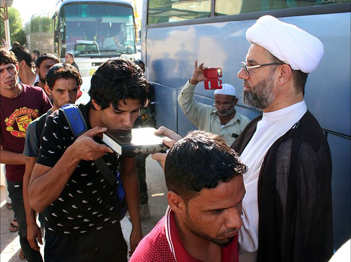 An Iraqi civilian, volunteering to fight a militant offensive, kisses a Koran book as he queues with comrades before boarding buses to reach Mosul on June 15, 2014, in the southern port city of Basra. Leading Shiite cleric Grand Ayatollah Ali al-Sistani urged Iraqis on June 13