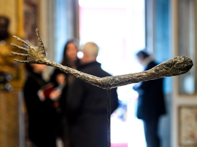 RESTRICTED TO EDITORIAL USE, MANDATORY CREDIT OF THE ARTIST, TO ILLUSTRATE THE EVENT AS SPECIFIED IN THE CAPTION Visitors stand behind the sculpture 'The Hand' of Swiss painter and sculptor Alberto Giacometti, as part of the exhibition of paintings and sculptures 'Giacometti La Scultura', at the Galleria Borghese Art Gallery, in Rome, on February 3, 2014. AFP PHOTO / ANDREAS SOLARO