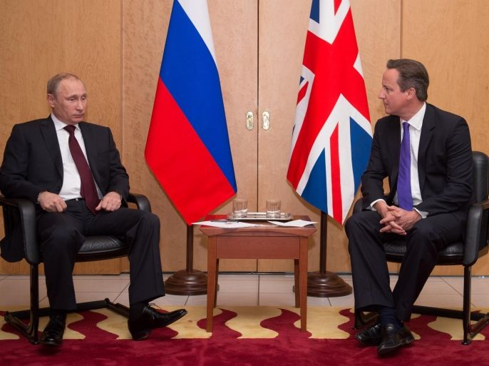 British Prime Minister David Cameron, right, meets with Russian President Vladimir Putin at Charles De Gaulle Airport in Paris, as they travelled to France ahead of the 70th anniversary of D-Day commemorations, Thursday June 5, 2014. David Cameron said he gave Russian president Vladimir Putin a "very clear and firm set of messages" during face-to-face talks in Paris about the crisis in Ukraine and told him the status quo was "not acceptable". The hastily arranged meeting happened after the leaders of the G7 warned that Russia could face damaging economic sanction unless it changed course. (AP Photo/ Stefan Rousseau, Pool)